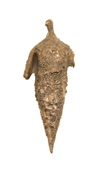 Statuette of a highly stilized human figure that has been elongated to form a pointed head, ind…