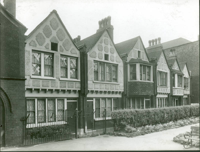 Black and white photograph of Redcross Gardens, a row of six mock Tudor style cottages built by…