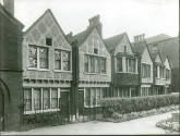Black and white photograph of Redcross Gardens, a row of six mock Tudor style cottages built by…