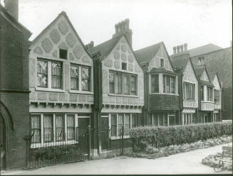Black and white photograph of Redcross Gardens, a row of six mock Tudor style cottages built by…