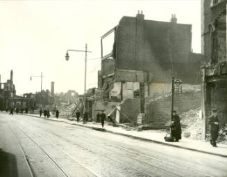 Black and white photograph showing extensive bomb damage to buildings on the west side of the W…