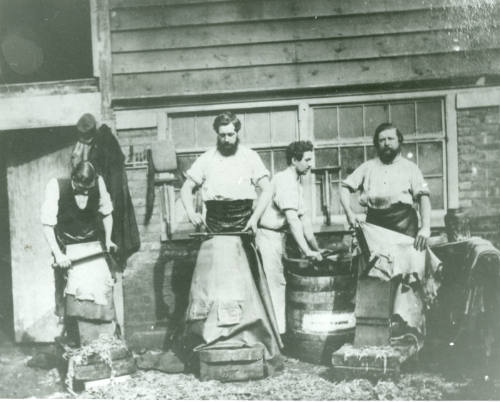 Photograph decipting workers working leather and animal hides at the Neckinger Leather Mills, i…